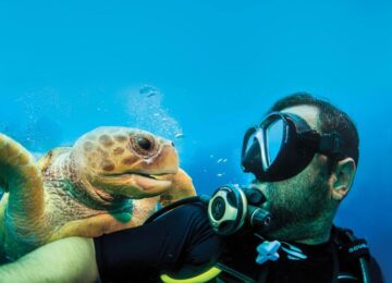 a-man-enjoying-his-scuba-diving-adventure-with-a-turtle-off-the-coast-of-staniel-cay-the-bahamas-1024×683